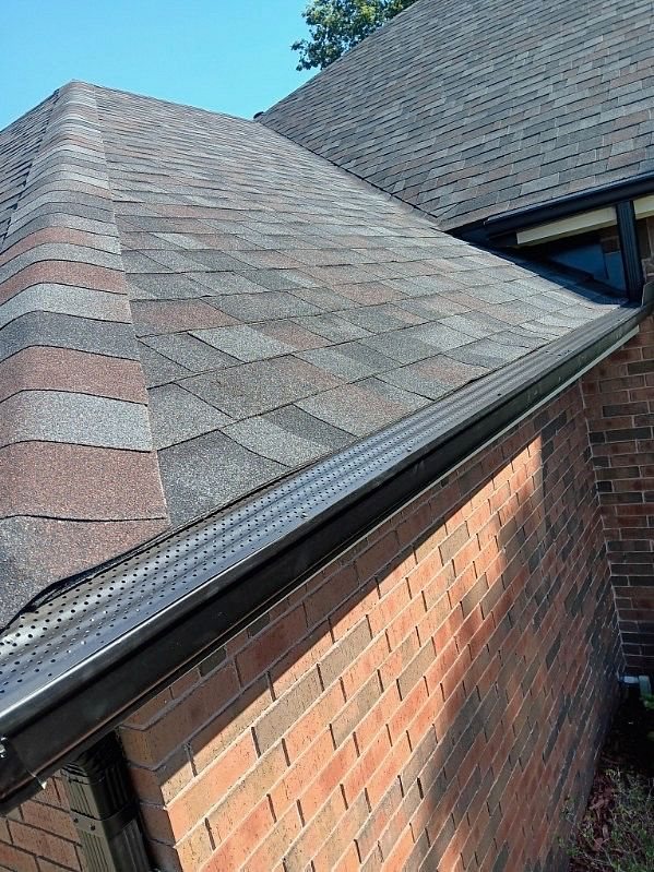 New dark gutter with a perforated gutter guard along the roof edge of a Bartlesville, Oklahoma home