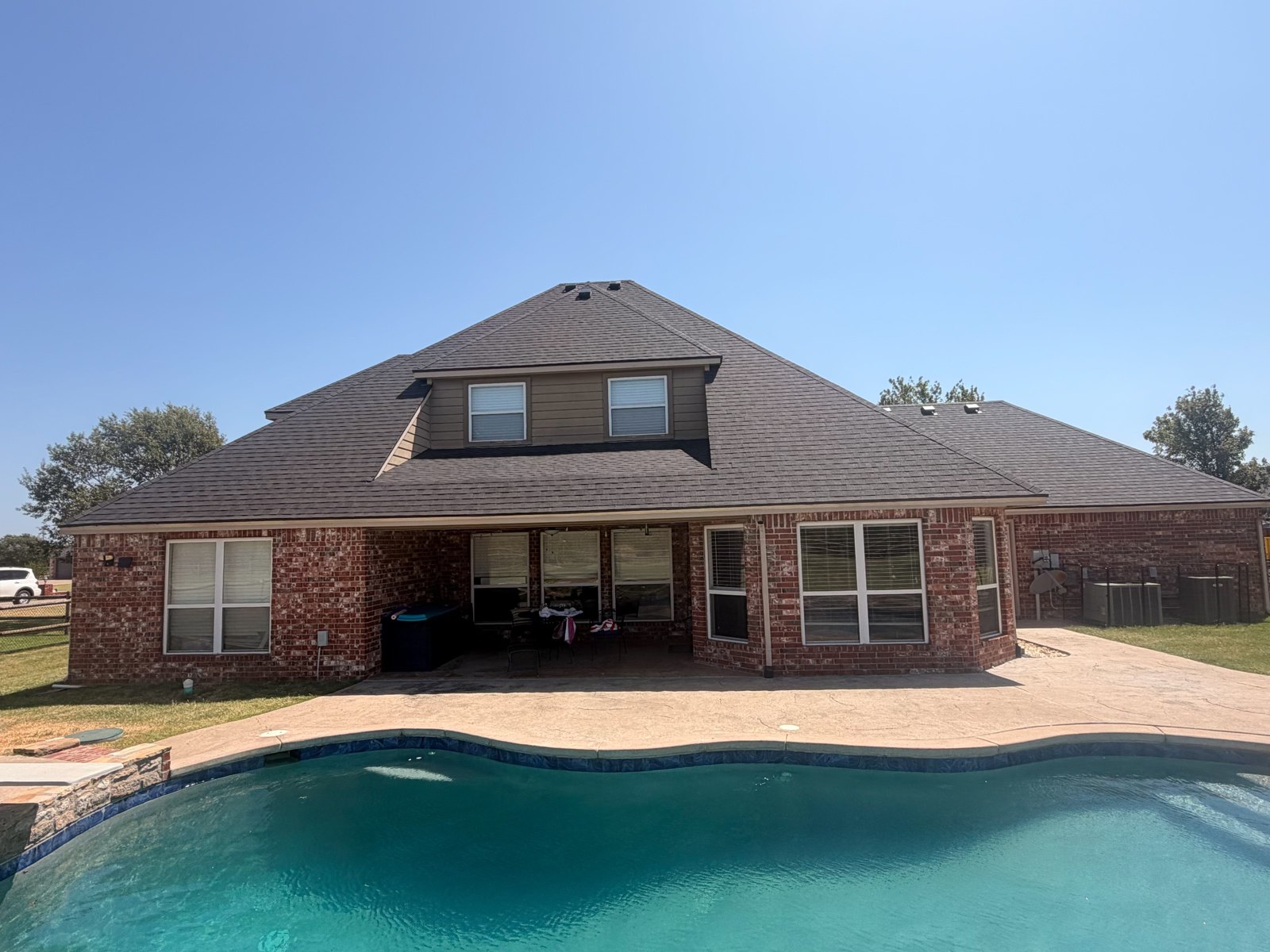 Completed shingle roof on a brick home in Collinsville, Oklahoma