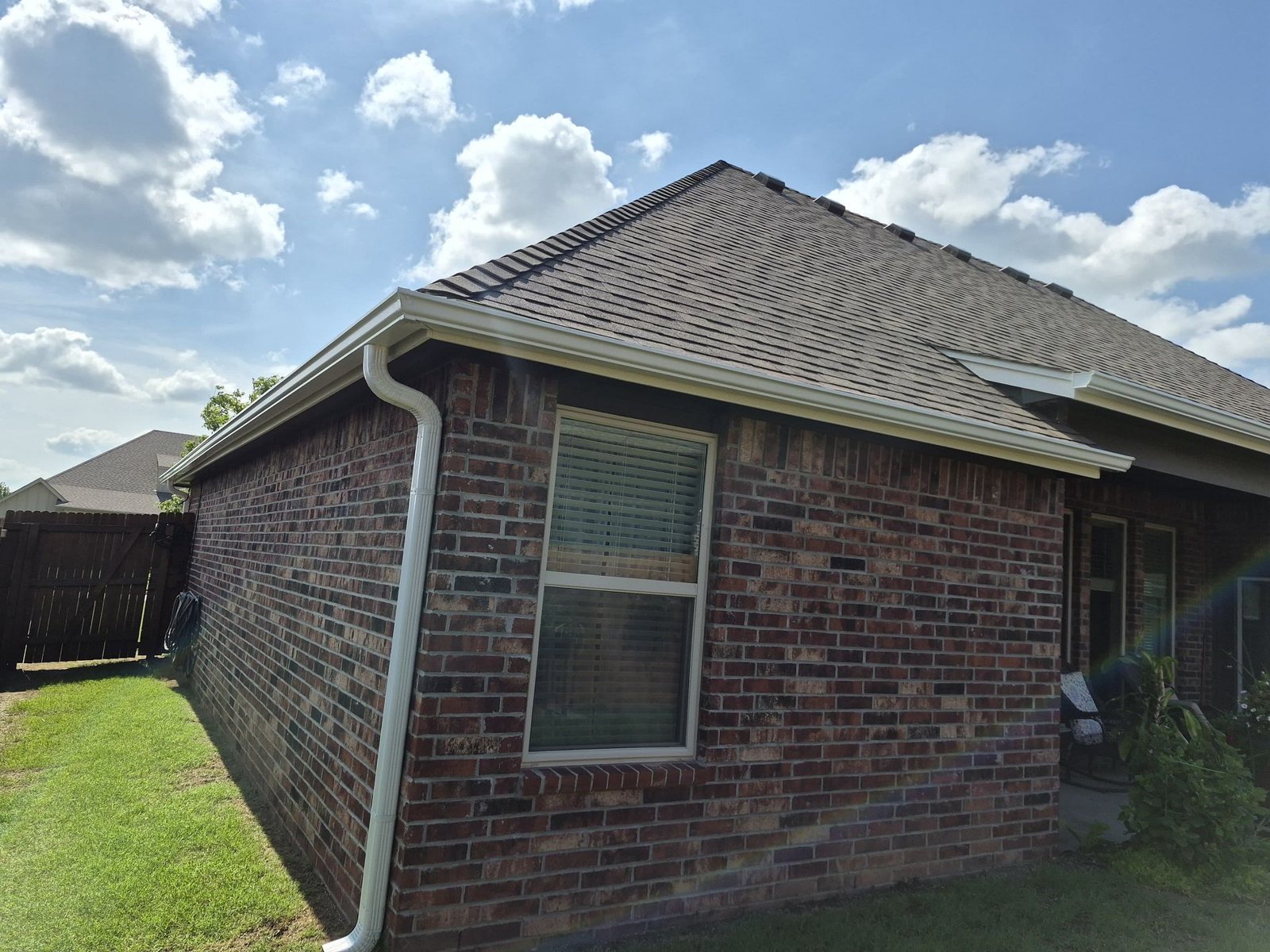 Rear of a brick home in Collinsville, Oklahoma with a new Mitten roof in Weathered Wood