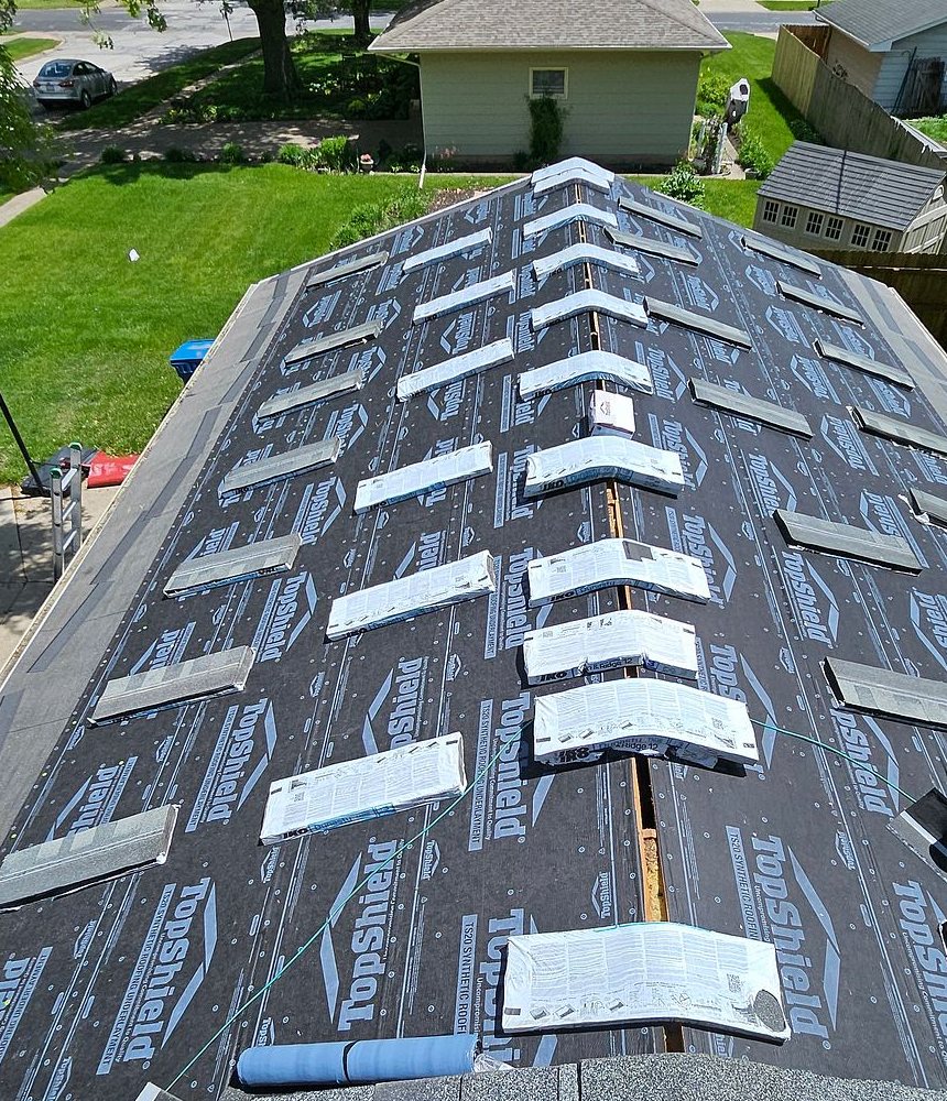 Synthetic underlayment and staged shingle bundles during a Mitten roof replacement in Eldridge, Iowa
