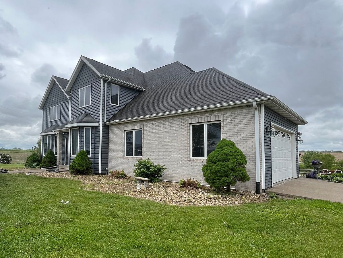 Front of the same Long Grove, Iowa home after Mitten's Riverway siding and Moire Black roof