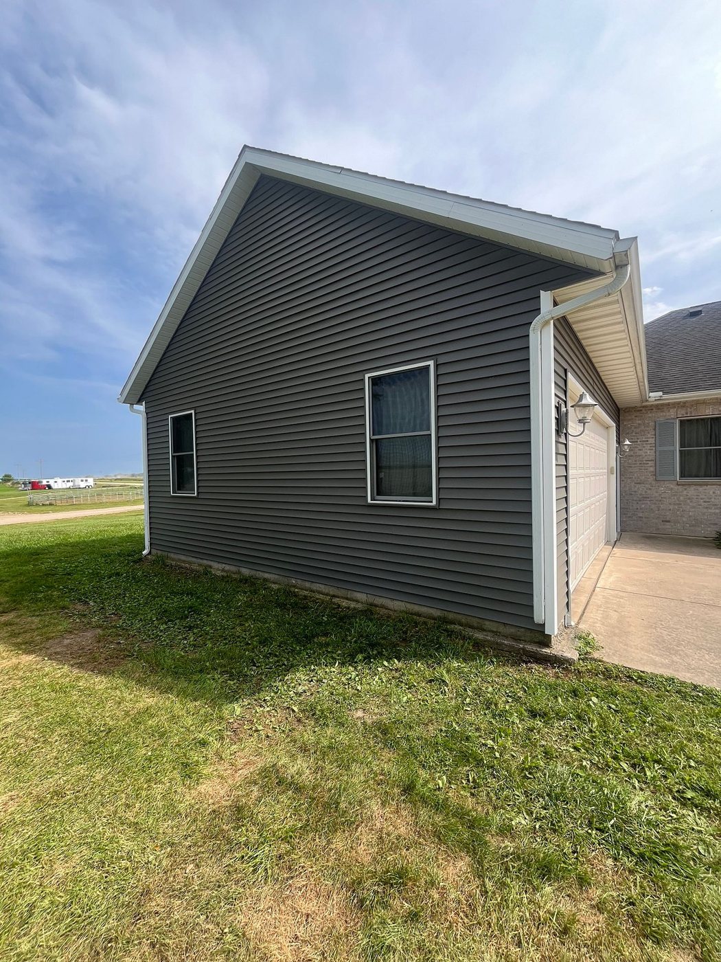 New gray vinyl siding with white trim on the garage of a home in Long Grove, Iowa, by Mitten