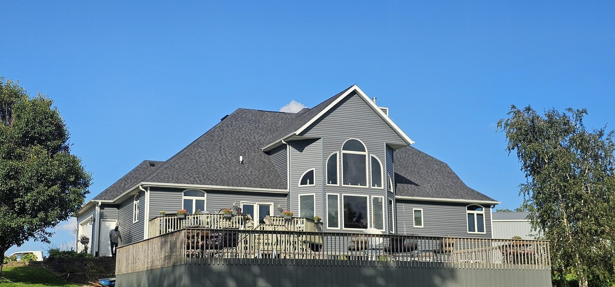 Completed gray roof and siding with white trim in Long Grove, Iowa