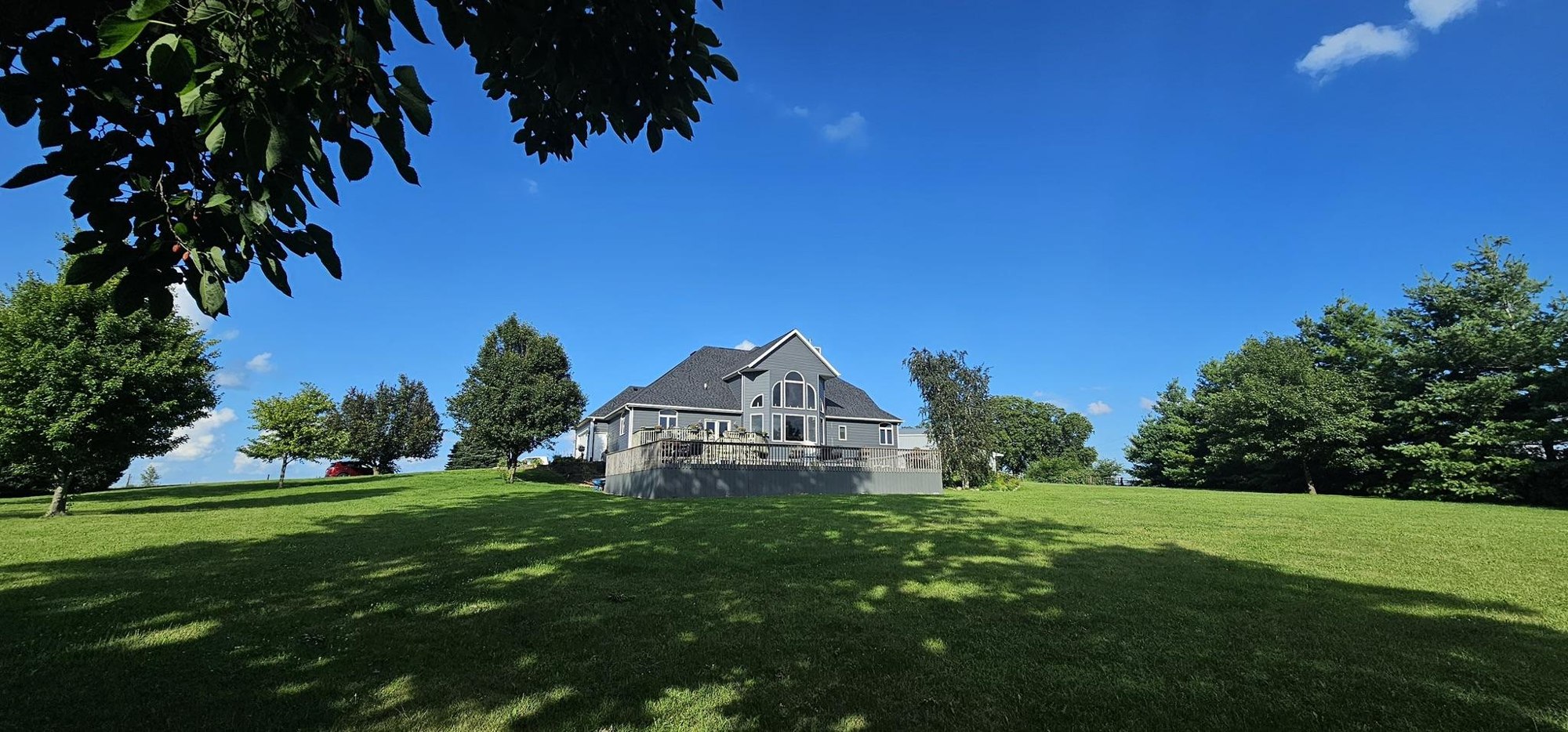 Finished Mitten roof and exterior viewed across the lawn in Long Grove, Iowa