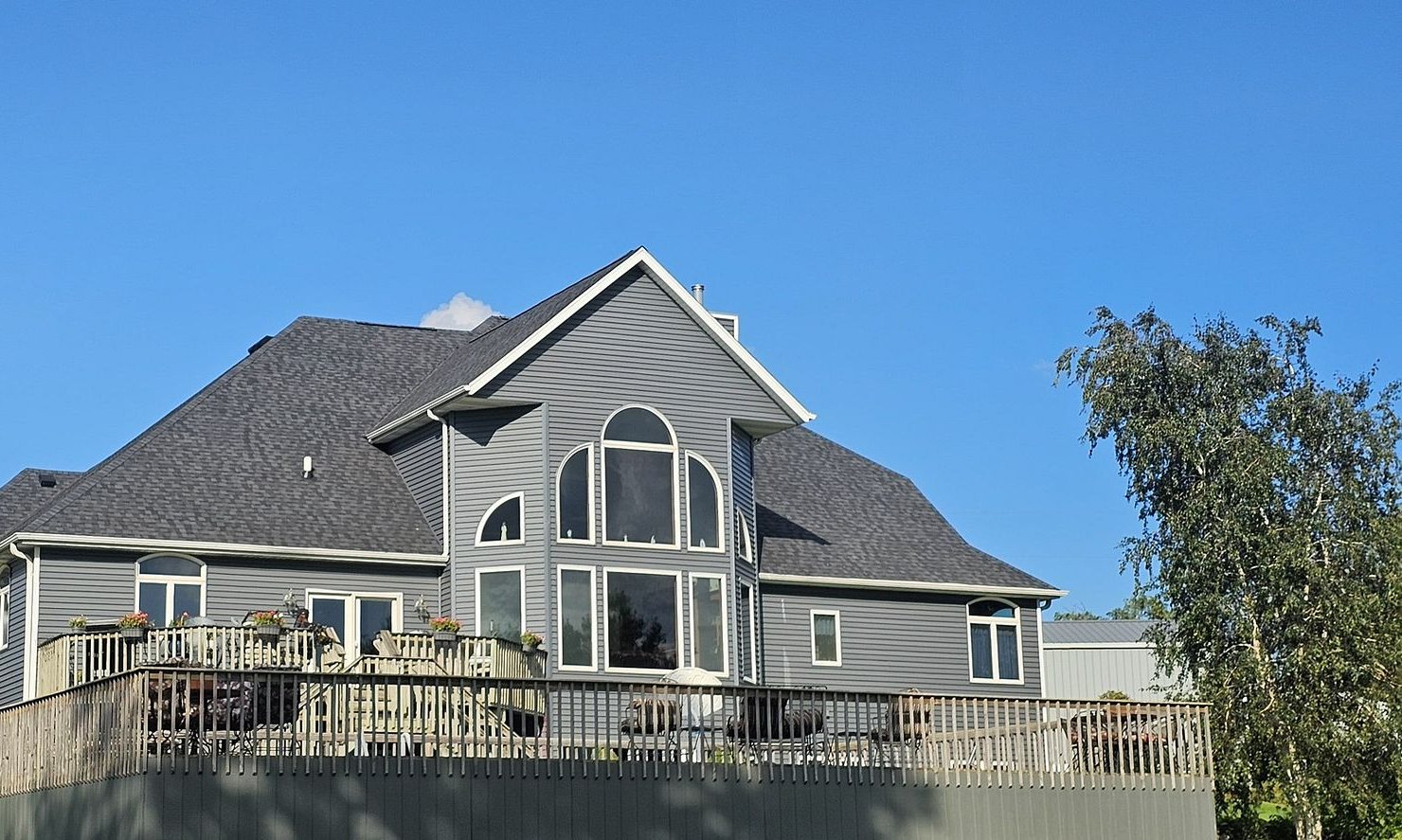 Back of the same Long Grove, Iowa home after Mitten installed Royal Estate Riverway siding and a CertainTeed Landmark Pro Moire Black roof