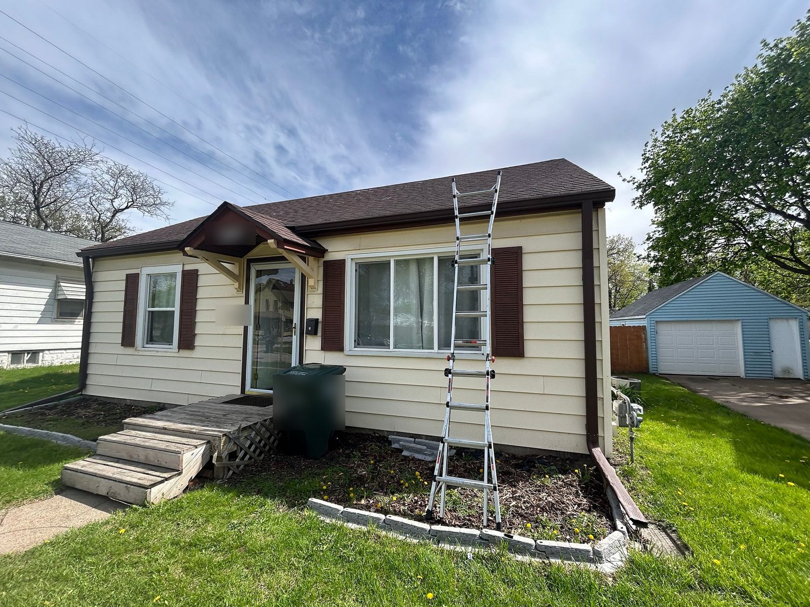 Small cream-sided home in Waterloo, Iowa with its old roof before Mitten's roof and siding project
