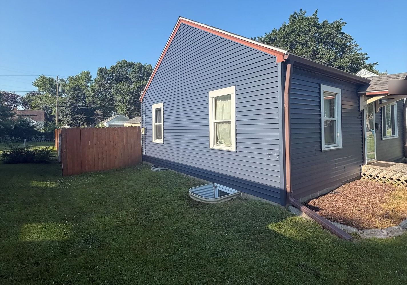 Navy blue vinyl siding on the gable end of a Waterloo, Iowa home after Mitten's roof and siding project